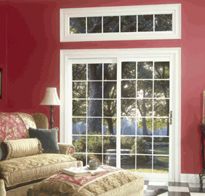 White-frame patio doors with white grids shown from living room with red walls looking out on a tree-shaded patio