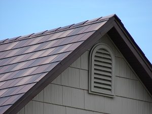 Detail shot of a roof peak with steel roofing panels that resemble textured shingles