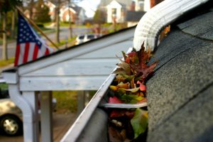Close up of a home's gutters with leaves and debris