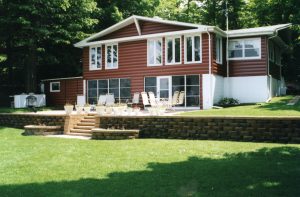 Rear of beautiful house with white windows and brown siding