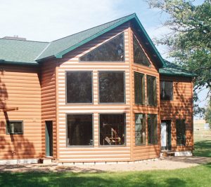Front of modern house with many windows and steel log cabin siding