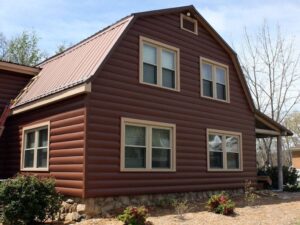 Side of house with earthy red toned metal siding and double-hung windows