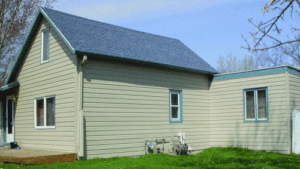 Quaint house pictured with new light yellow siding